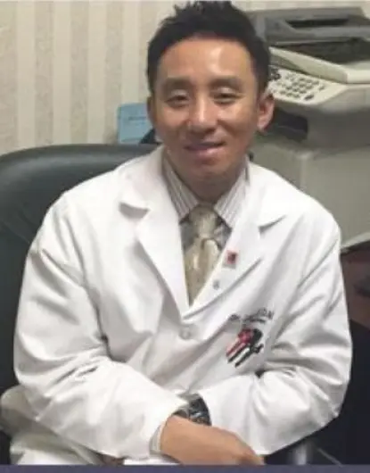 Dr. John Ji, dentist at Silver Spring dental practice, smiling in white coat.